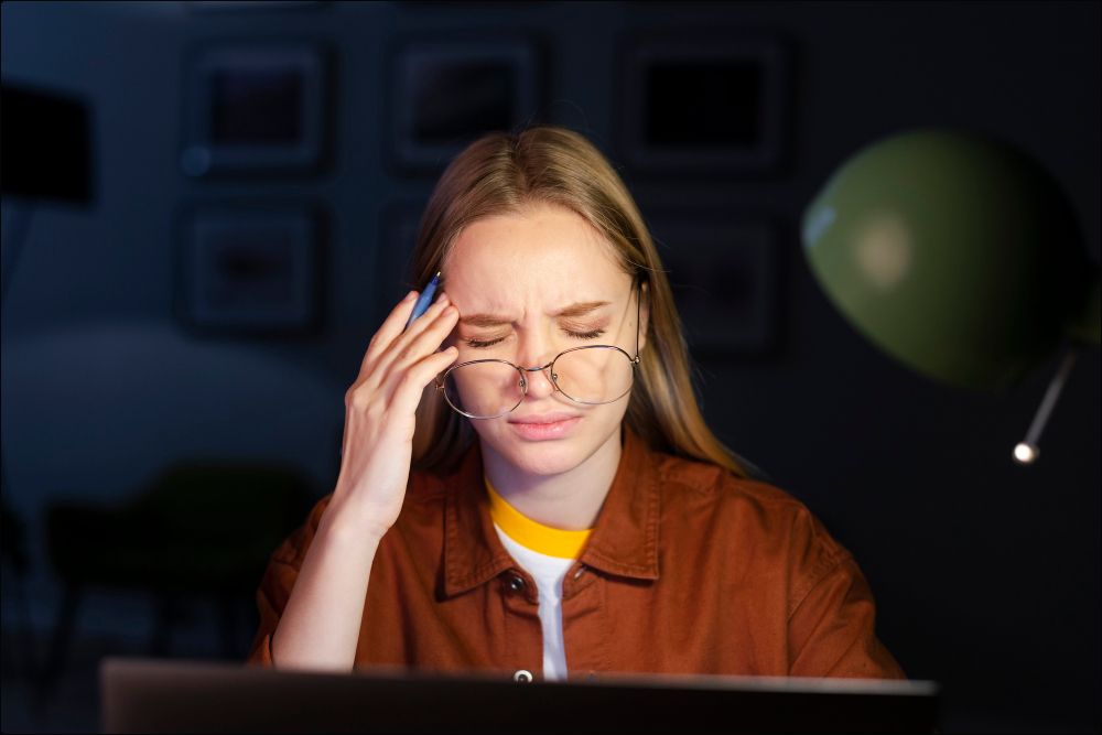 foto de una mujer que tiene síndrome visual informático que mira la pantalla de una computadora