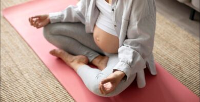 foto de mujer sobre una esterilla rosa practicando yoga para embarazadas