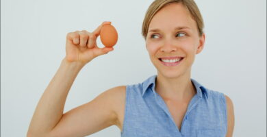 imagen de una mujer sosteniendo un huevo uno de los alimentos para mejorar la memoria