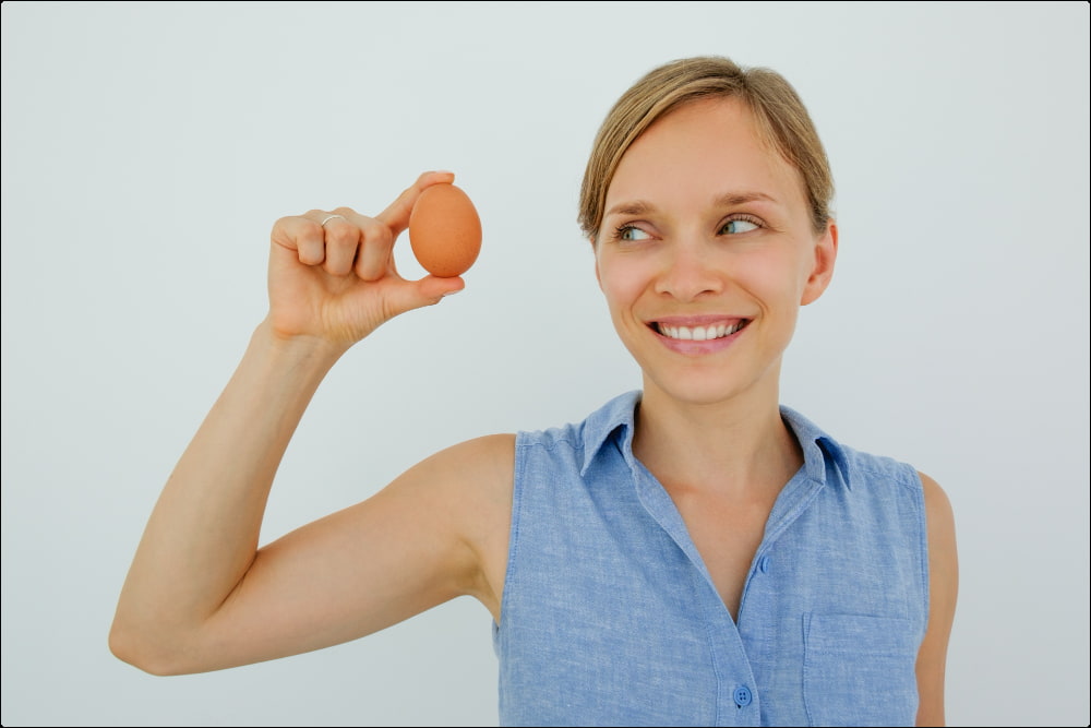 imagen de una mujer sosteniendo un huevo uno de los alimentos para mejorar la memoria