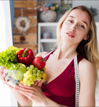 foto de una mujer rubia que soetiene un bol con alimentos que aumentan el tamaño de los senos