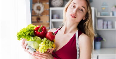 foto de una mujer rubia que soetiene un bol con alimentos que aumentan el tamaño de los senos