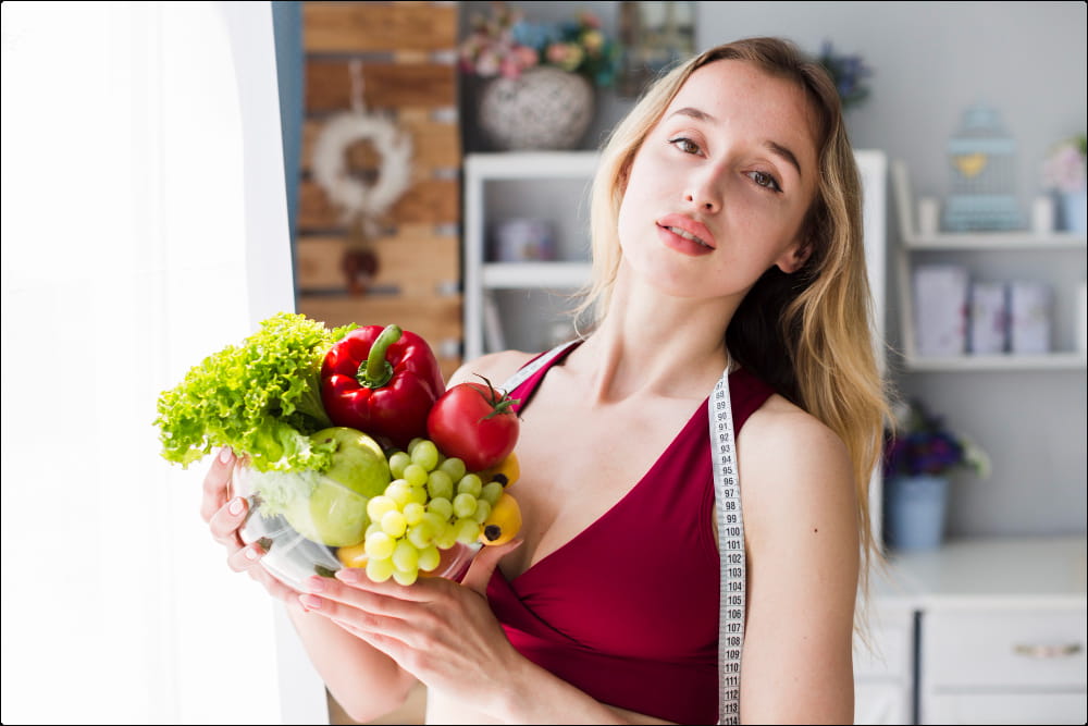 foto de una mujer rubia que soetiene un bol con alimentos que aumentan el tamaño de los senos