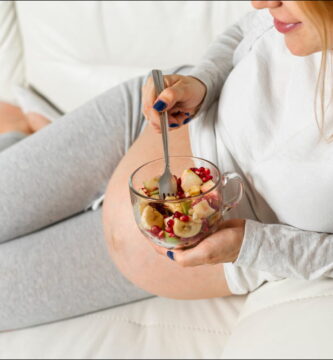foto de una mujer embarazada con un de frutas que representa la importancia de la alimentación en la fertilidad