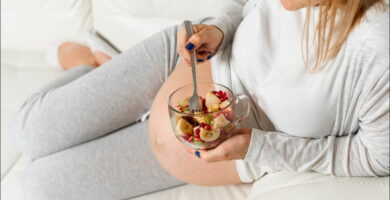 foto de una mujer embarazada con un de frutas que representa la importancia de la alimentación en la fertilidad