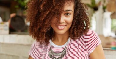 mujer de pelo rizado que está sonriendo a cámara