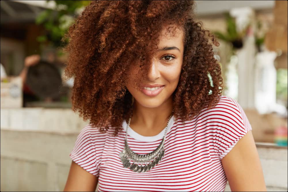 mujer de pelo rizado que está sonriendo a cámara