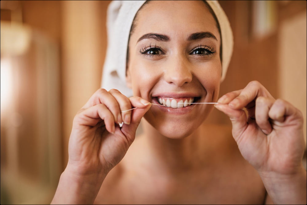 foto de una mujer sobre como usar bien el hilo dental