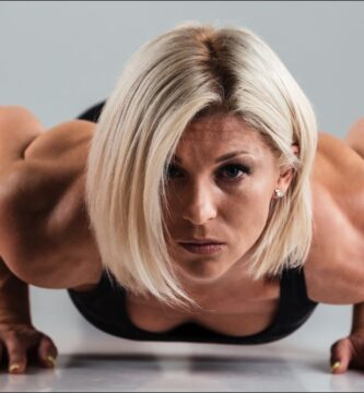 imagen de una mujer con definición una definición muscular óptima haciendo flexiones en el suelo