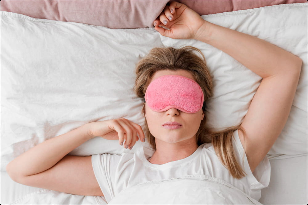 imagen de mujer con antifaz para dormir que practica una buena higiene del sueño