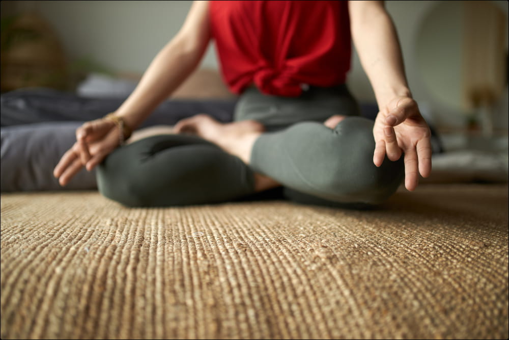 mujer con camiseta roja practicando la meditación en el suelo