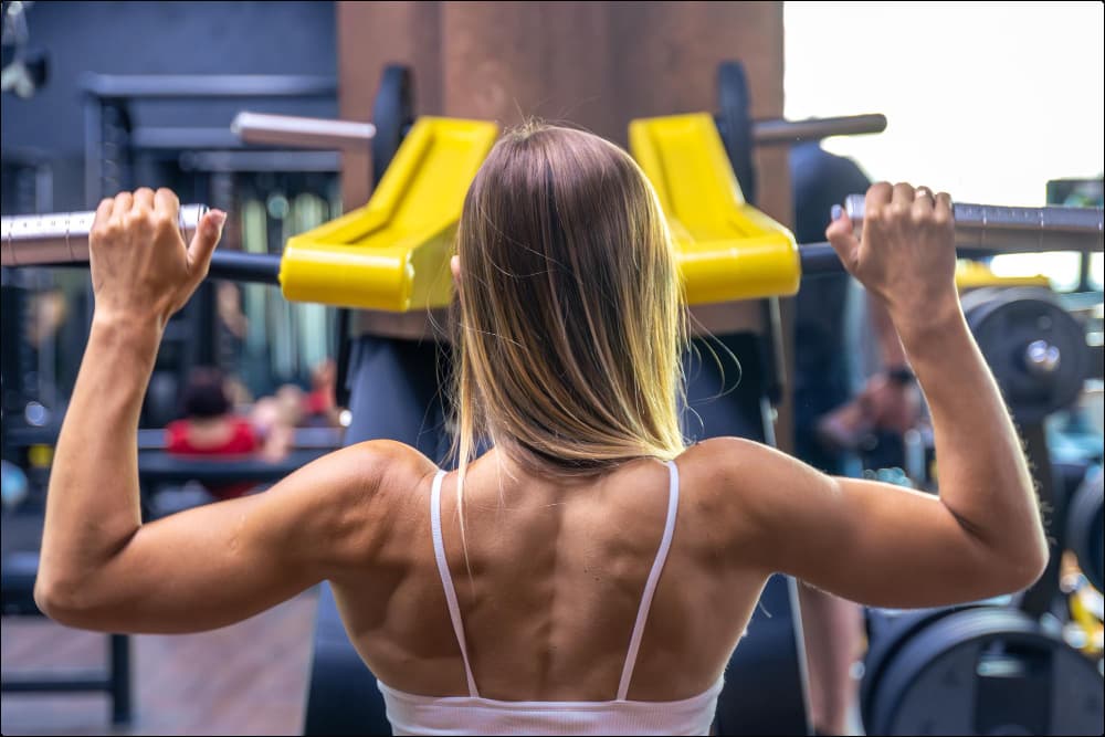 imagen de mujer practicando unos de los mejores ejercicios para espalda en el gym