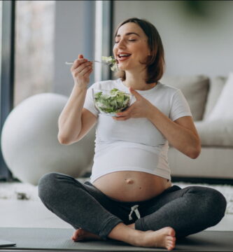 foto de una mujer embarazada en su salón que practica una buena nutrición durante el embarazo