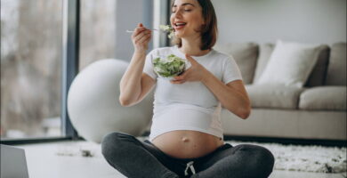 foto de una mujer embarazada en su salón que practica una buena nutrición durante el embarazo