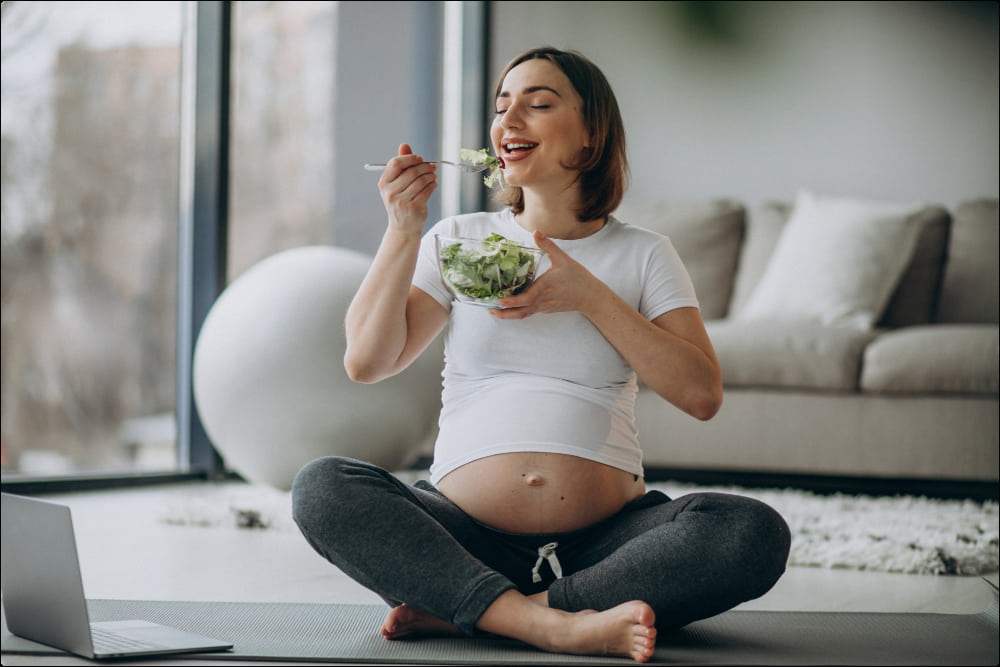 foto de una mujer embarazada en su salón que practica una buena nutrición durante el embarazo