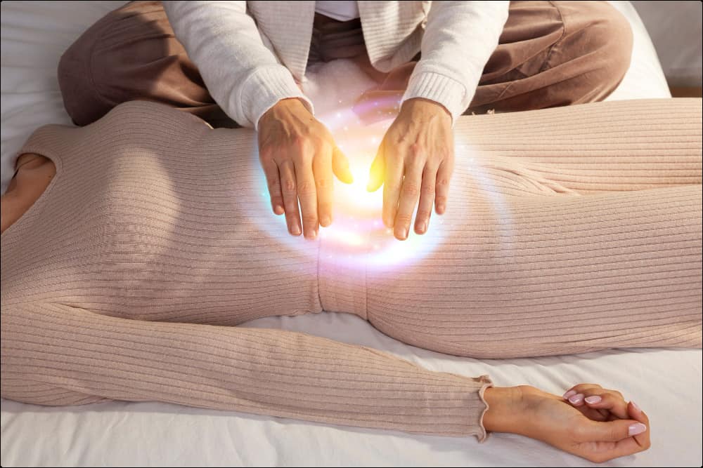 foto de una persona aplicando reiki a otra que está tendida en el suelo