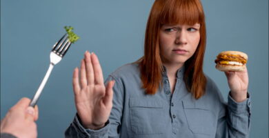 foto de mujer con colesterol alto que sostiene una hamburguesa t rechaza una lechuga